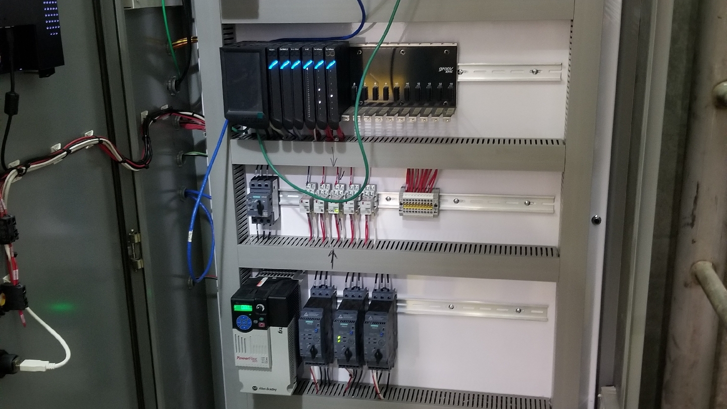 Control cabinet interior with DIN-rail modules and field wiring.