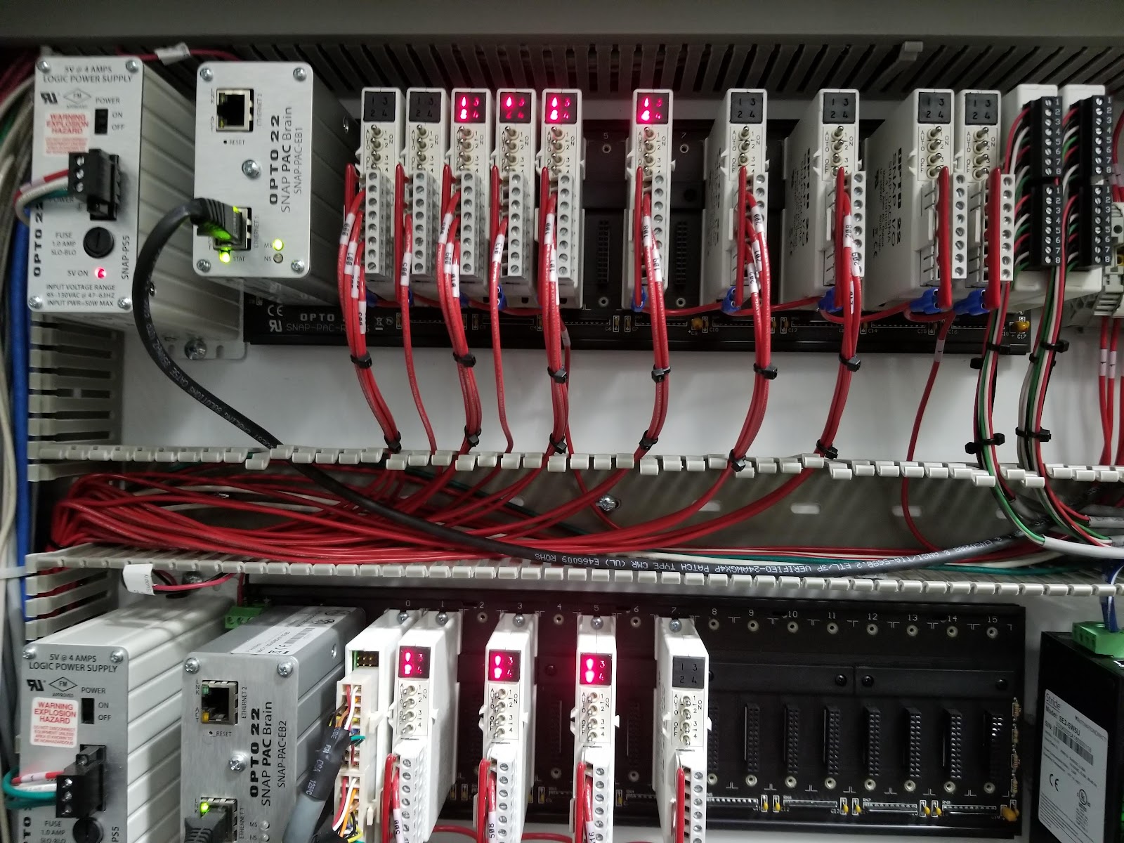 Allen-Bradley PLC racks with bundled red and white field wiring.