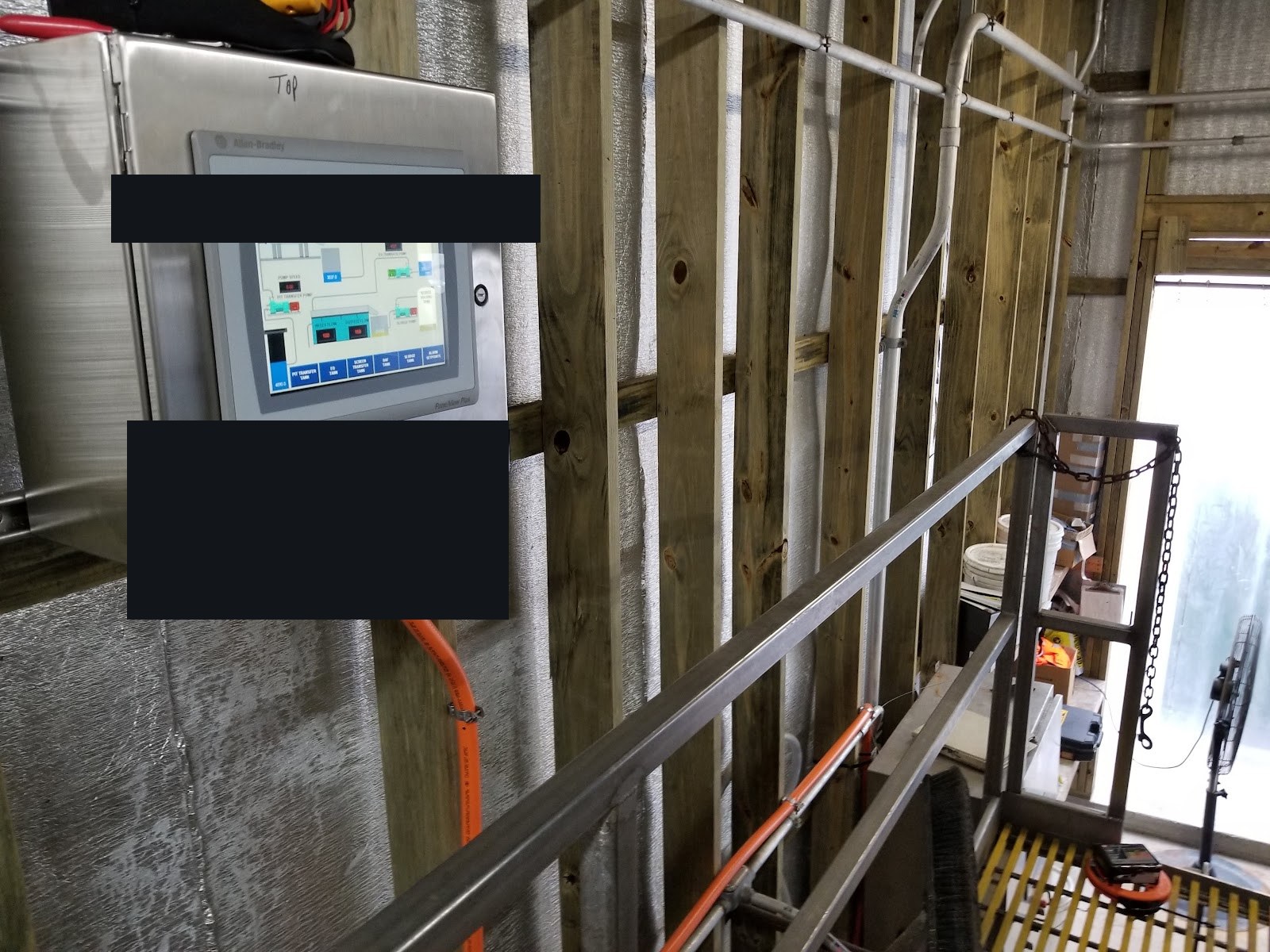 Wall-mounted stainless enclosure with a PanelView control screen.