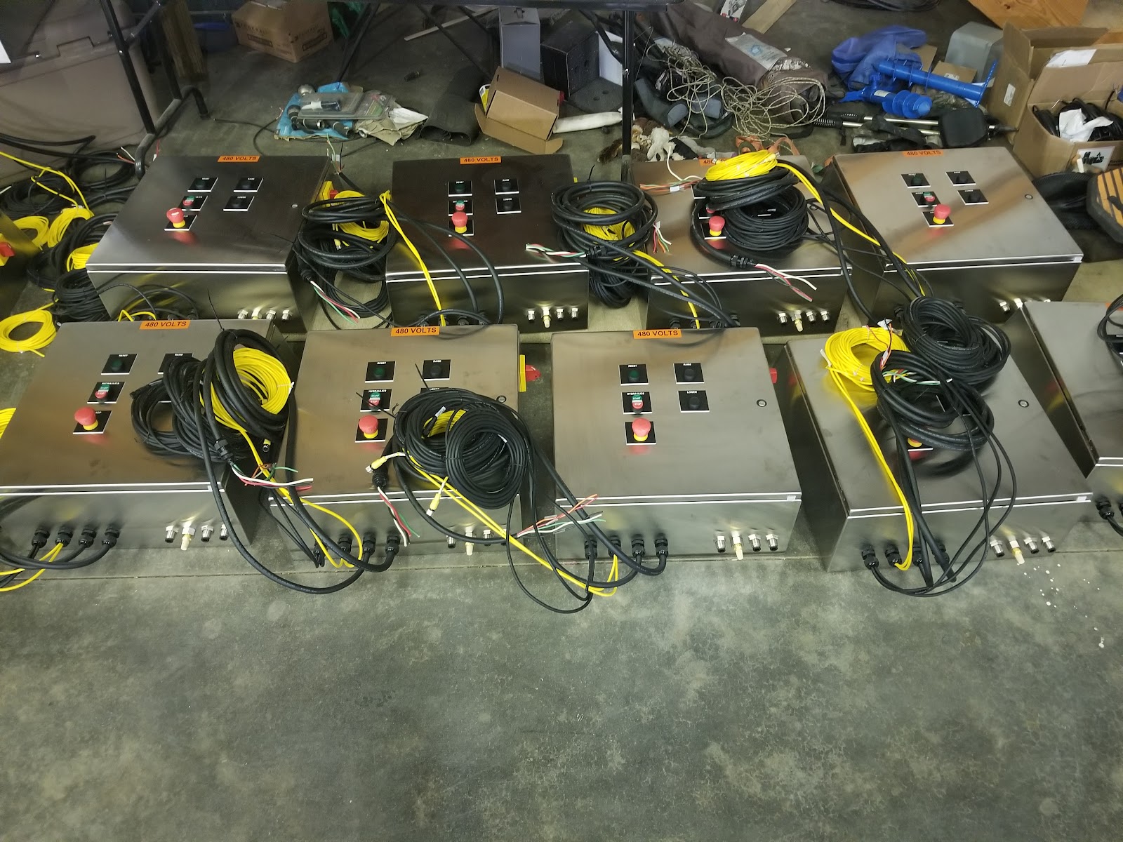 Row of stainless control enclosures on the shop floor, ready to ship.