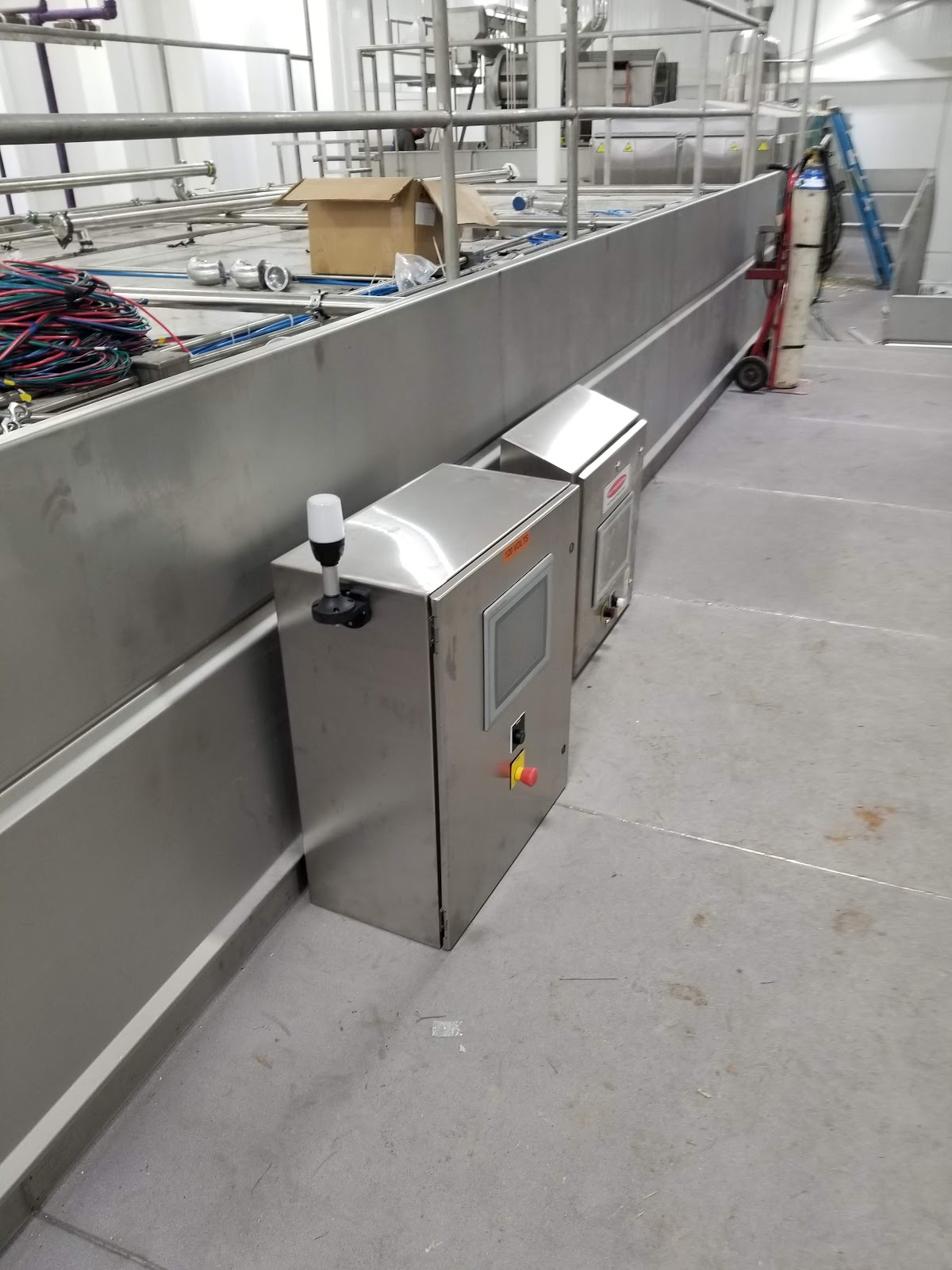 Stainless process equipment with a side-mounted control box.