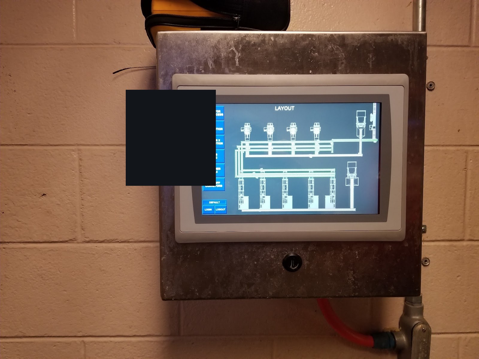 Wall-mounted HMI with a conveyor layout graphic.