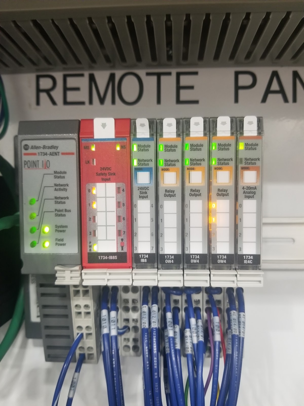 Allen-Bradley remote PLC rack with green status lights and blue wiring.