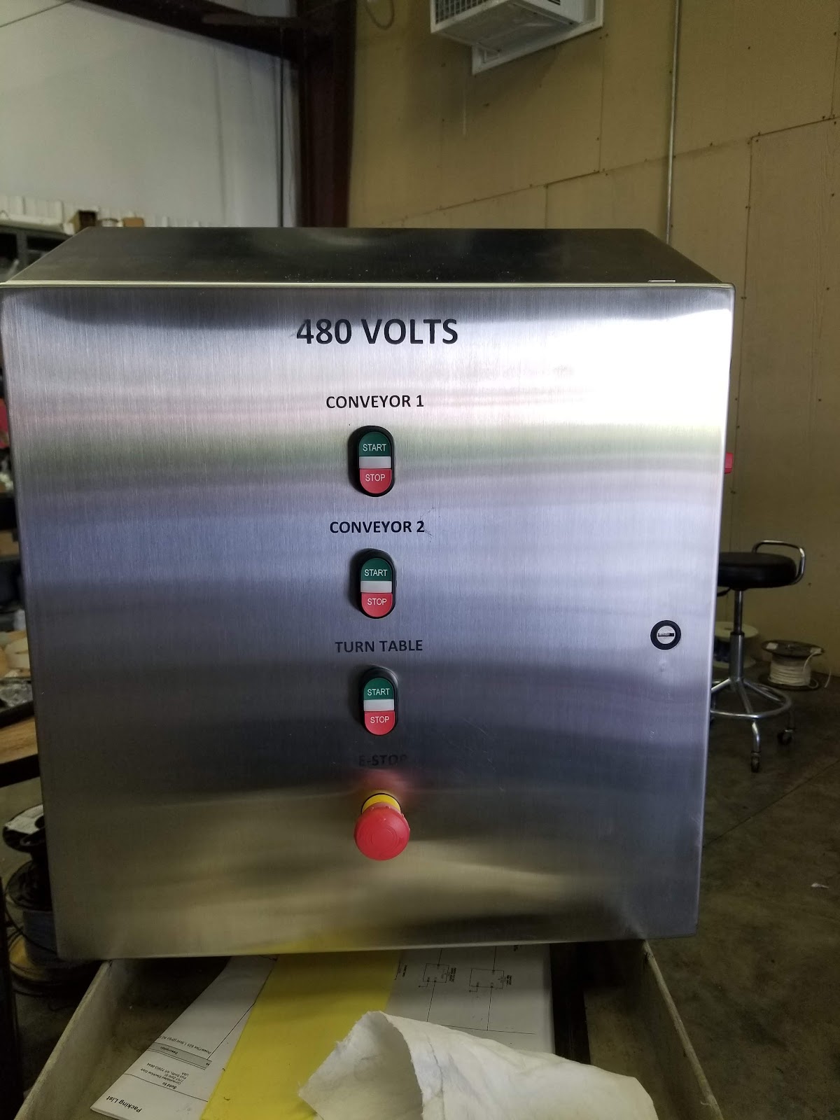 Stainless washdown operator station with conveyor selectors and emergency stop.