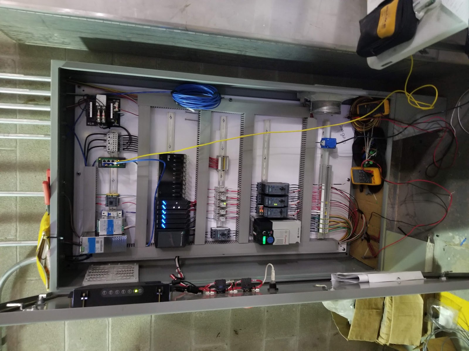 Wide open cabinet with a controller and rows of terminals.