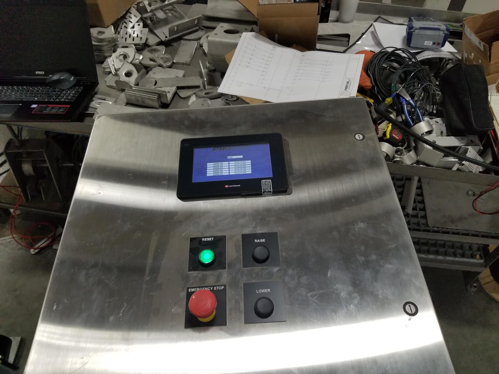 Stainless operator pedestal with HMI, selector, and emergency stop.