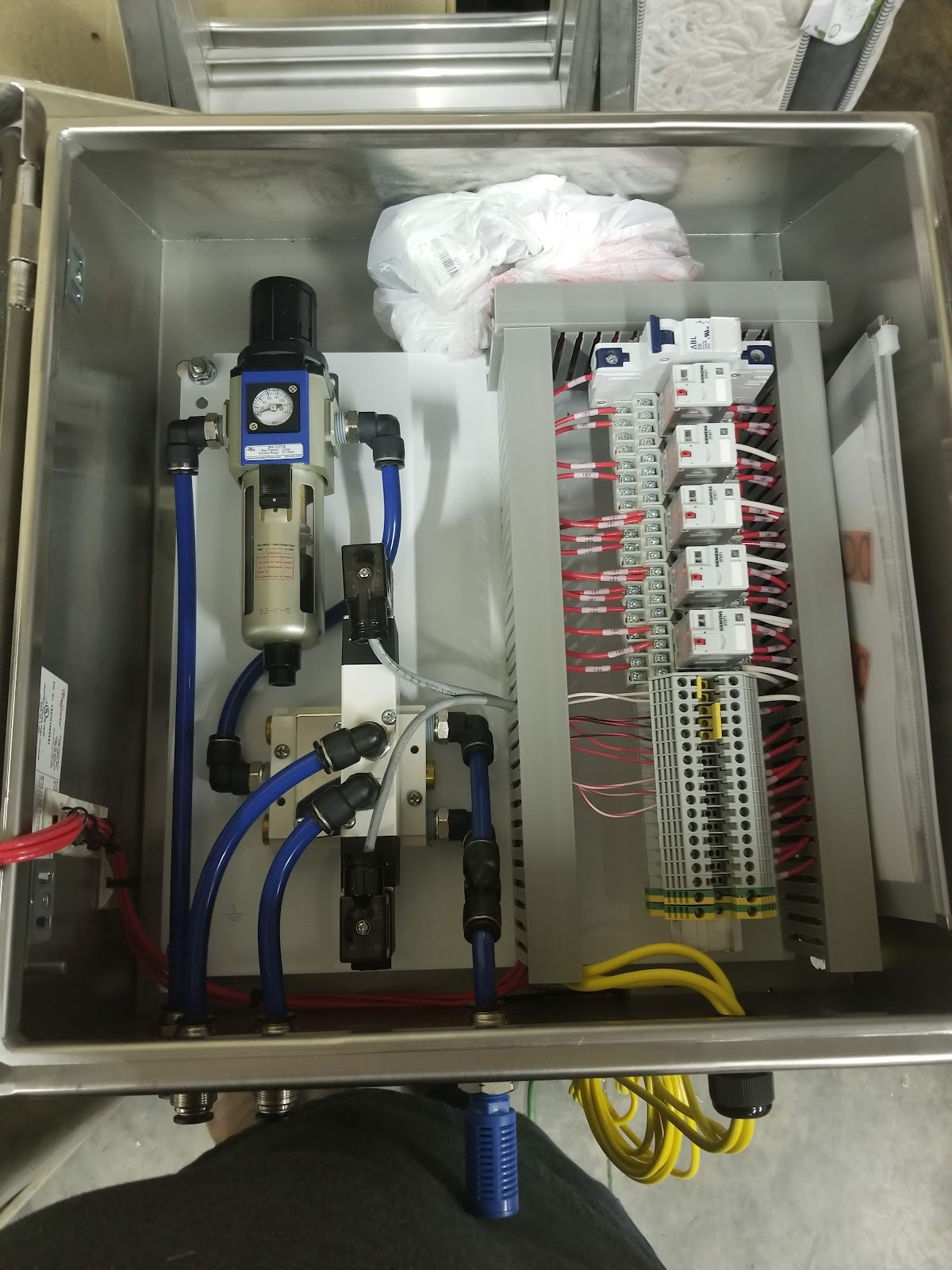 Stainless enclosure with pneumatic regulator and electrical modules.