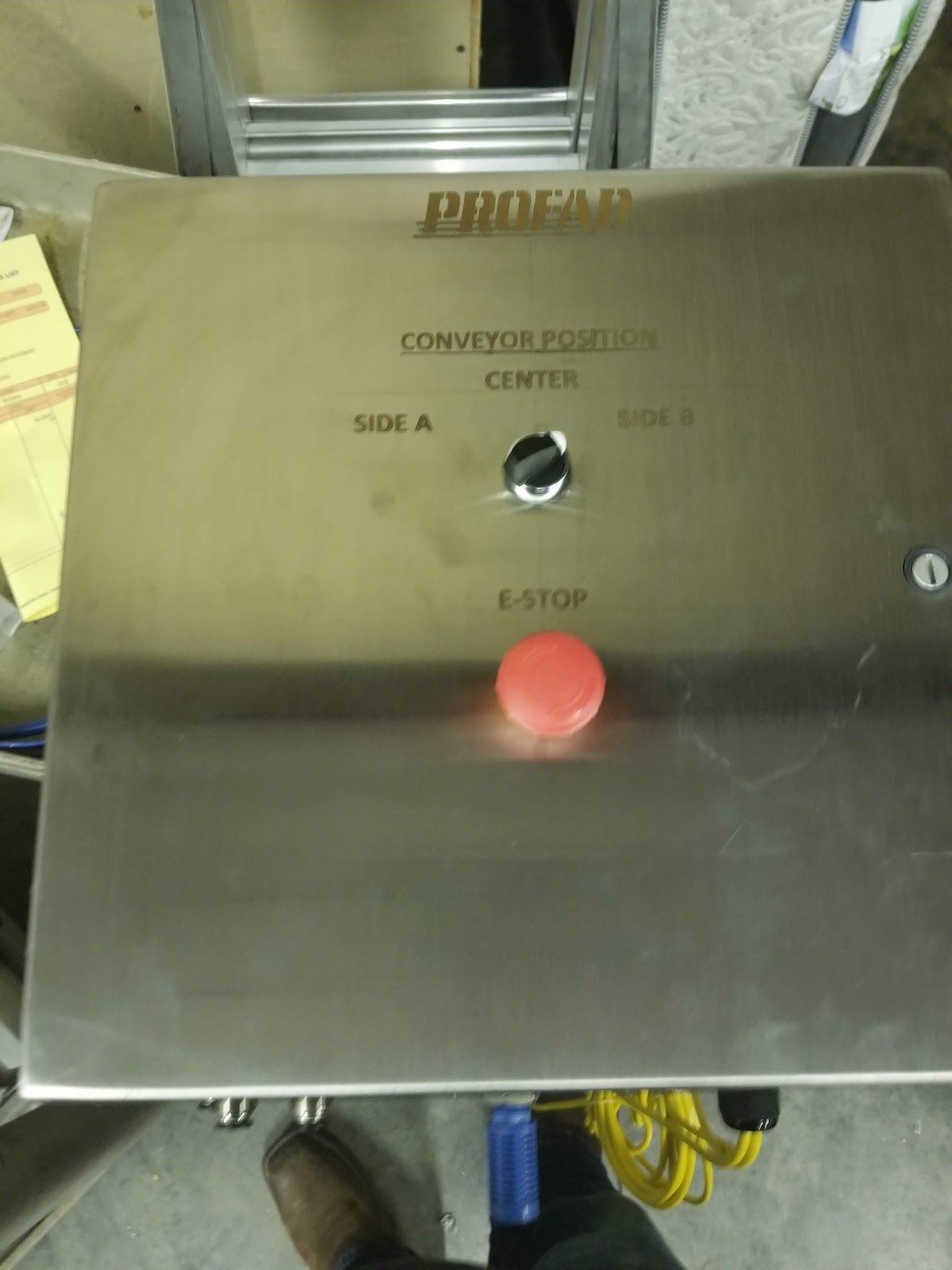 Stainless panel surface with a large red emergency stop.