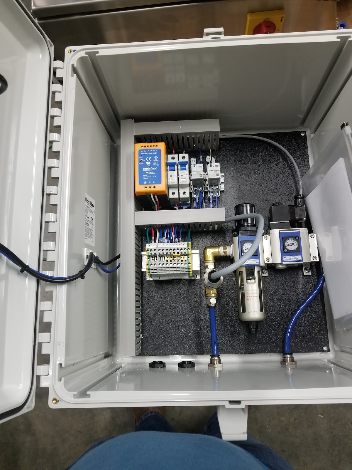 Stainless box interior with PLC and pneumatic solenoids.