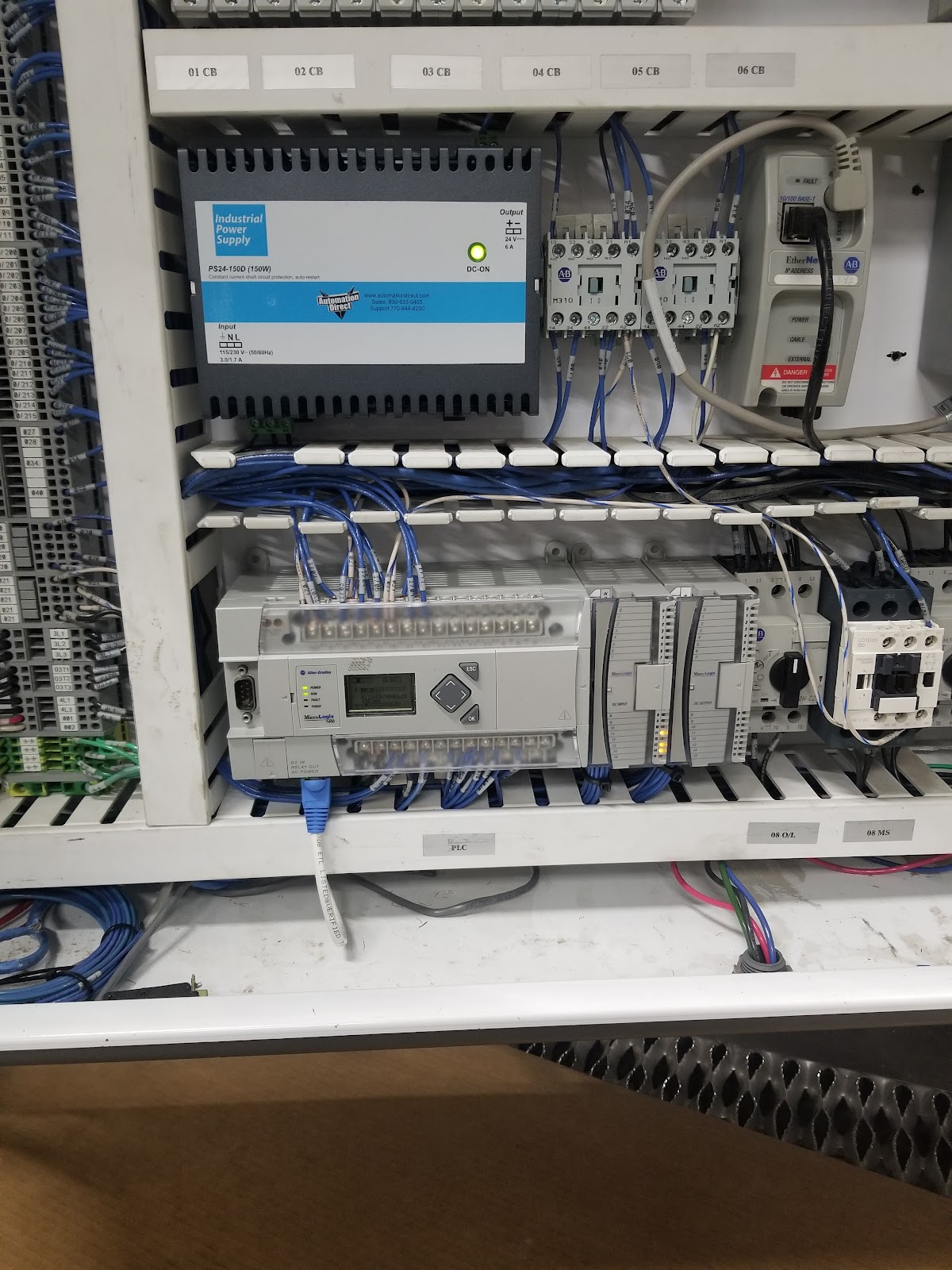 Large cabinet interior with Allen-Bradley PLC, power supplies, and terminals.