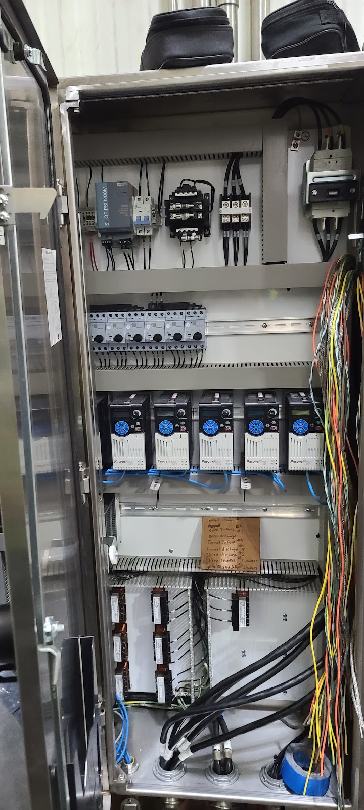 Narrow cabinet packed with relays and circuit breakers.