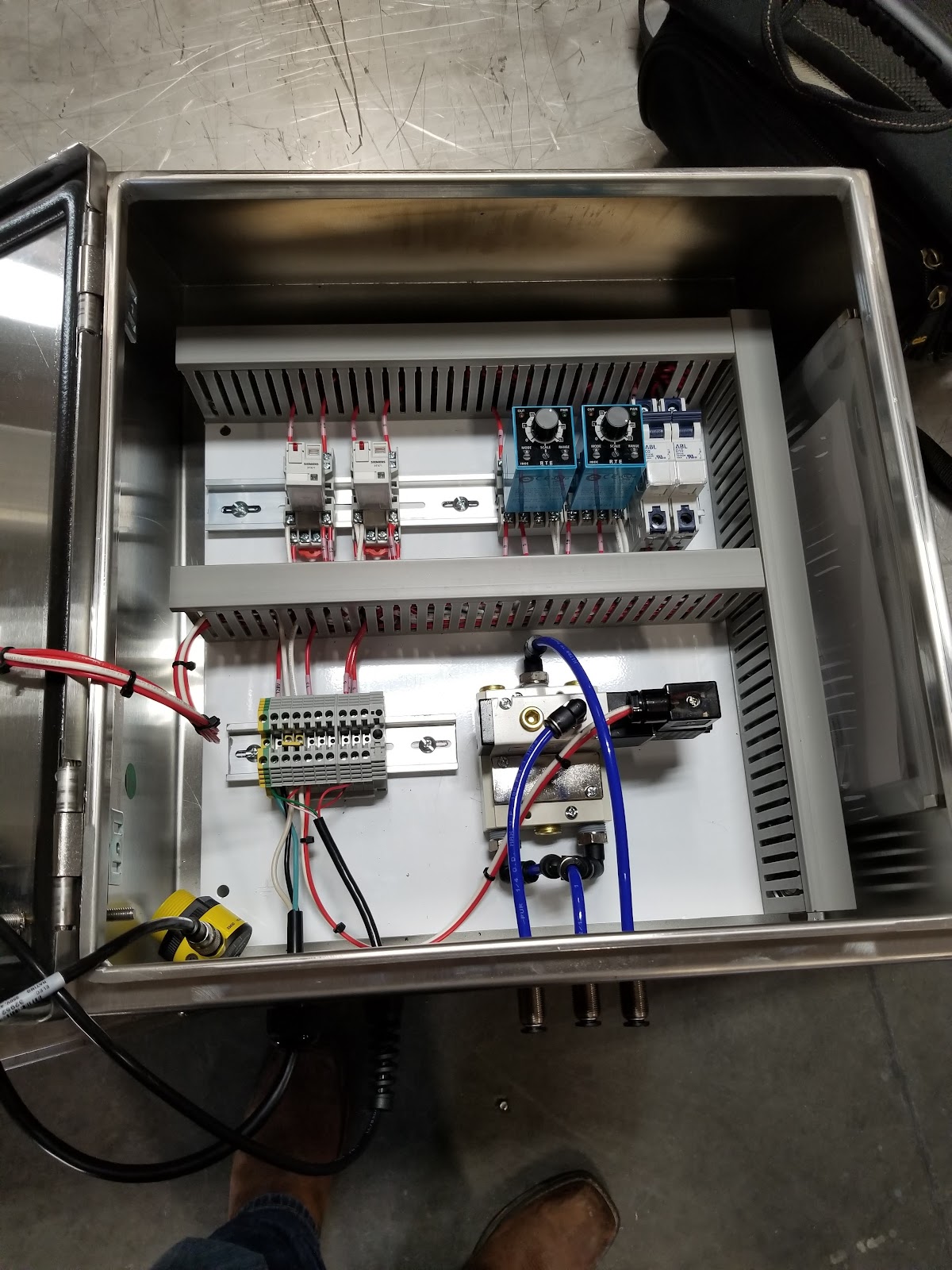 Open stainless box with two rows of components and wiring.