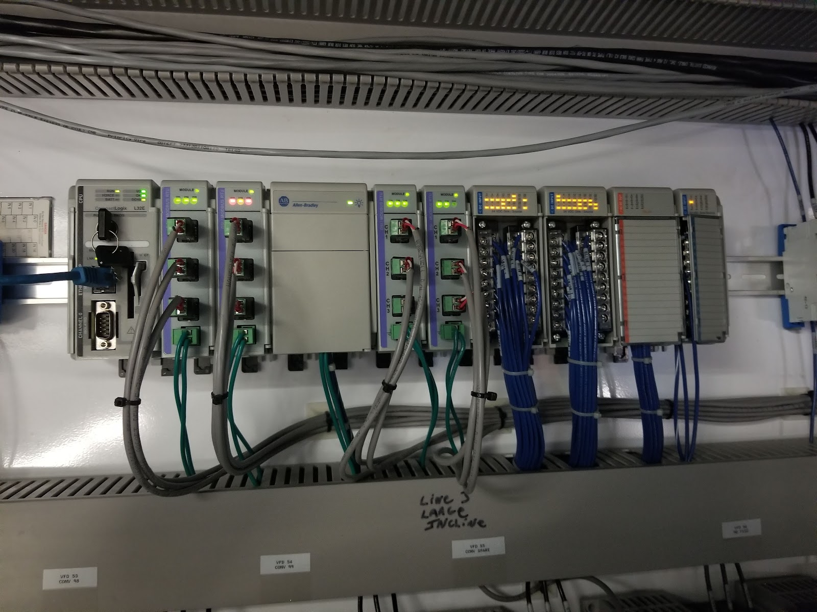 Allen-Bradley PLC rack with I/O modules and Ethernet cables.