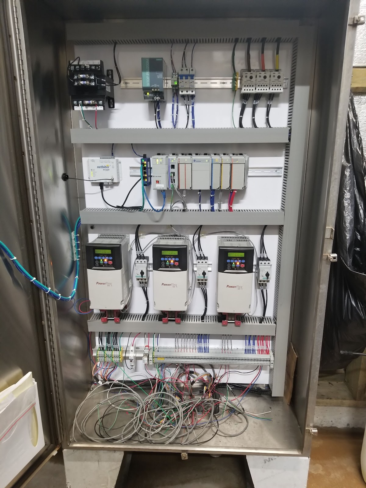 Open stainless cabinet with VFDs, PLC rack, and wire duct.
