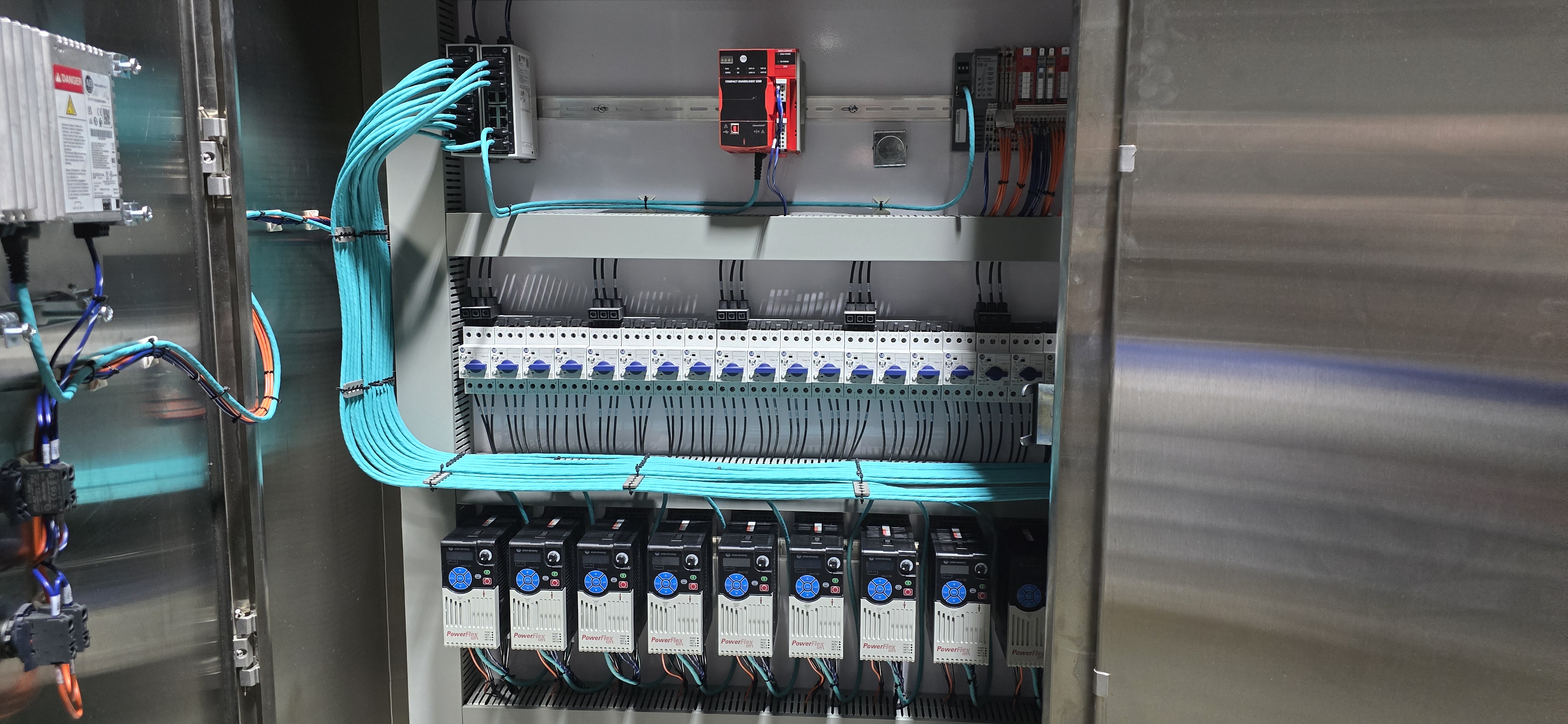 Open stainless enclosure with VFDs, motor starters, and dressed Ethernet.